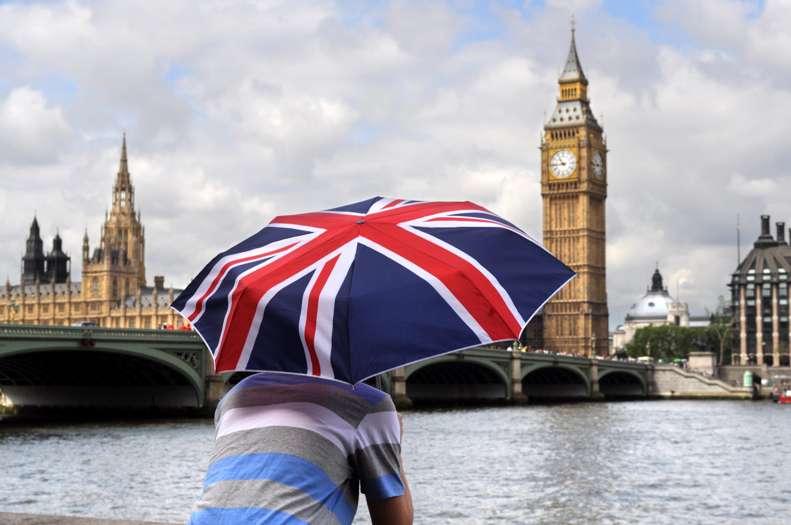 Big Ben and tourist with British flag umbrella in Southbank, London